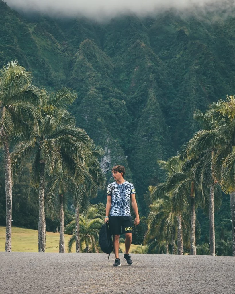 a man walking on a path with trees in the background