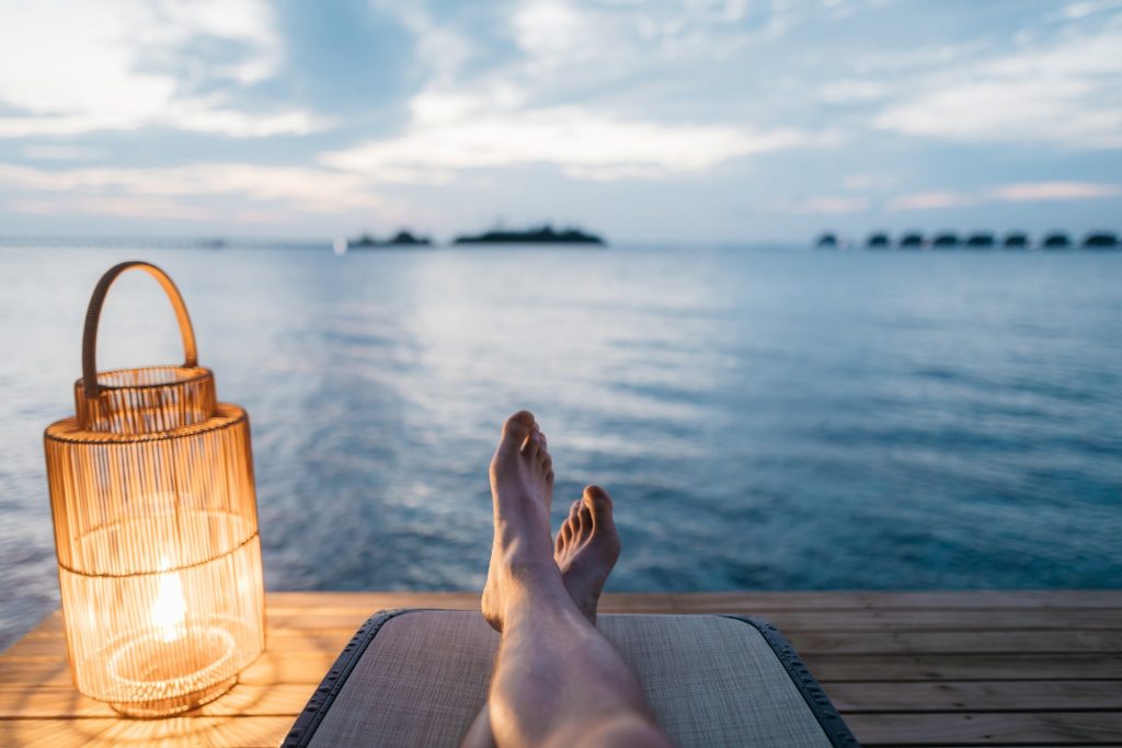 a person's feet on a table by a large body of water