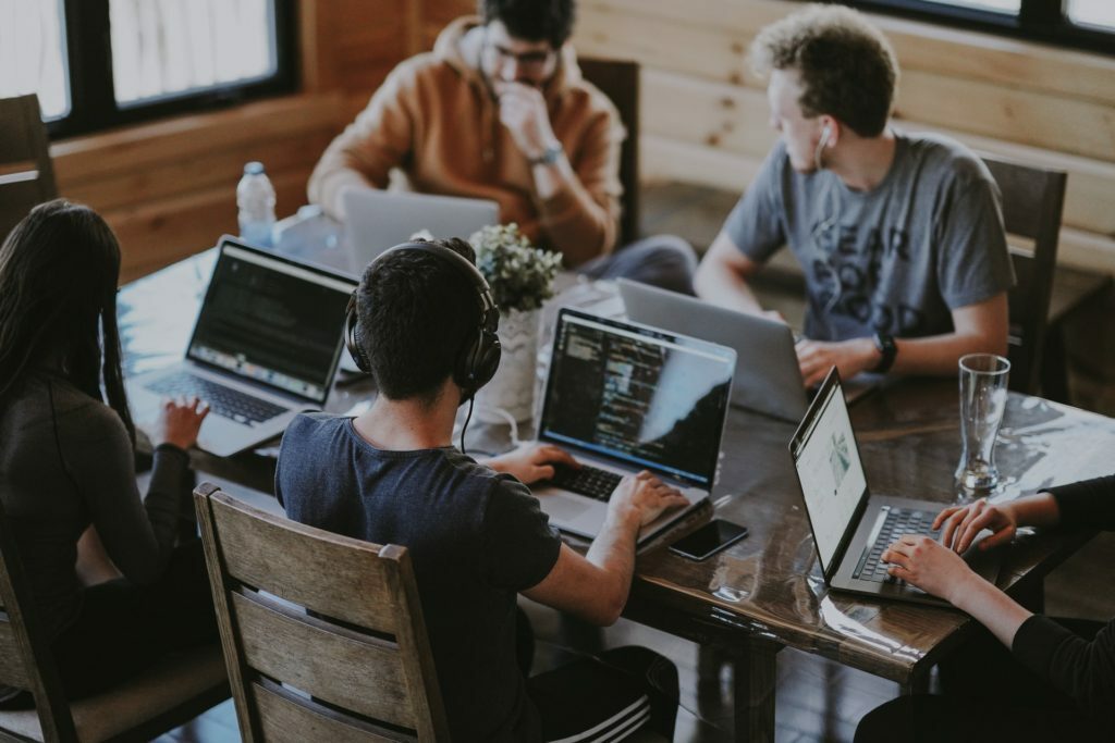 a group of people working on laptops