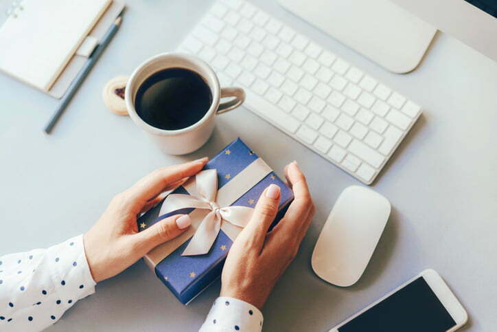 a person holding a pen and a pen next to a laptop