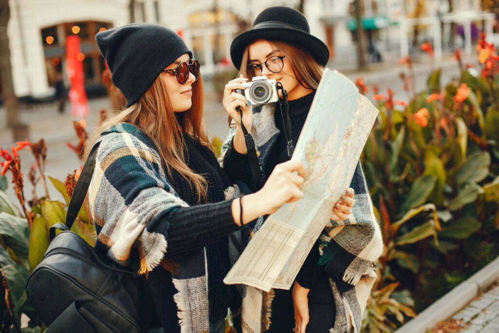 a woman holding a camera next to a man wearing a mask