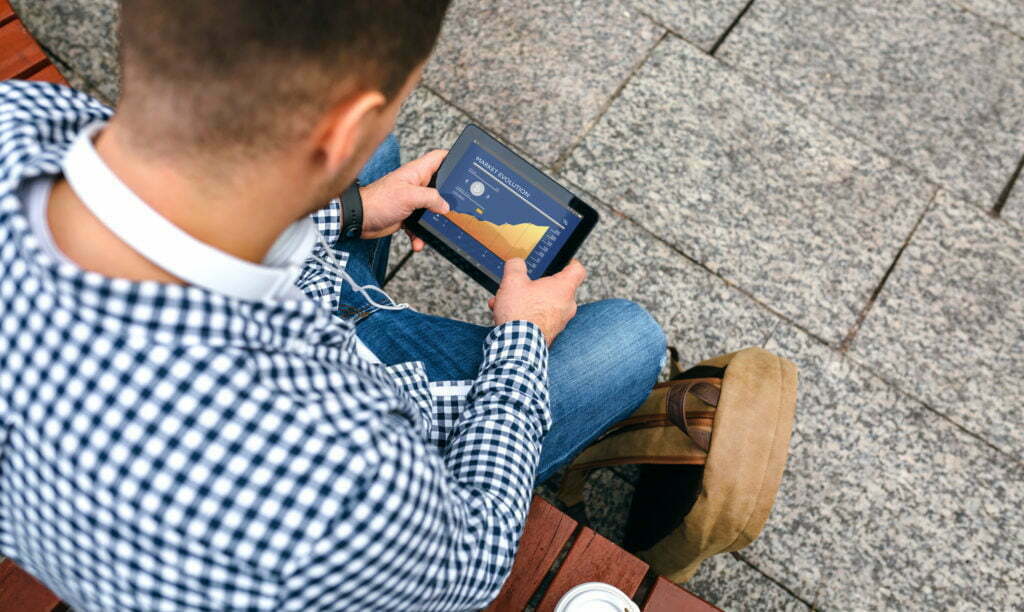 a man sitting on the ground looking at his phone